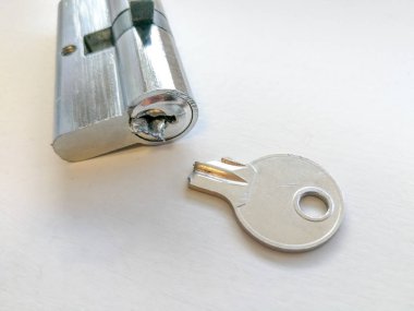 Broken key and lock with half of key inside close up clipart