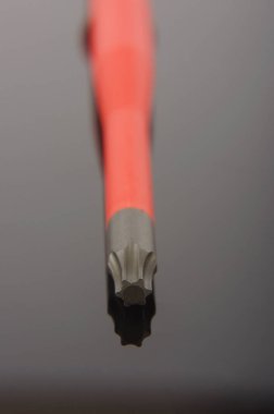 İpucu yakın çekim karanlık yansıtıcı arka plan üzerinde izole profesyonel tornavida