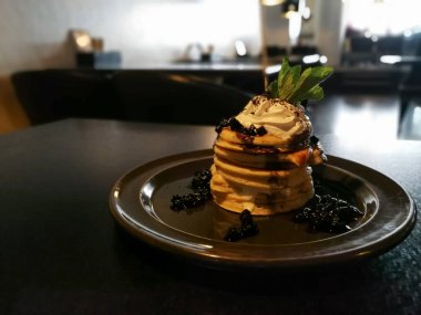 Koyu ahşap restoran masada yaban mersini ile Amerikan yığın krep