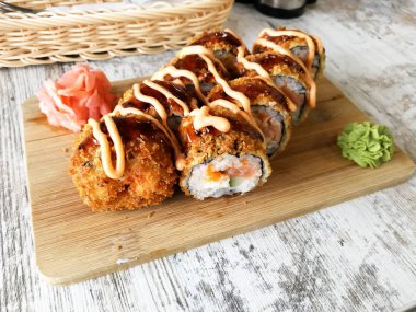 Somon, peynir ve zencefil ve wasabi ile avokado serwed sıcak kızarmış suşi rulo