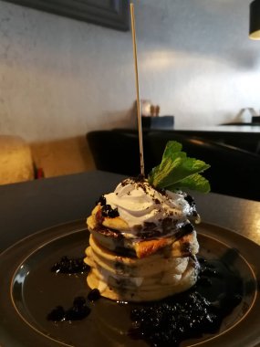 Koyu ahşap restoran masada yaban mersini ile Amerikan yığın krep