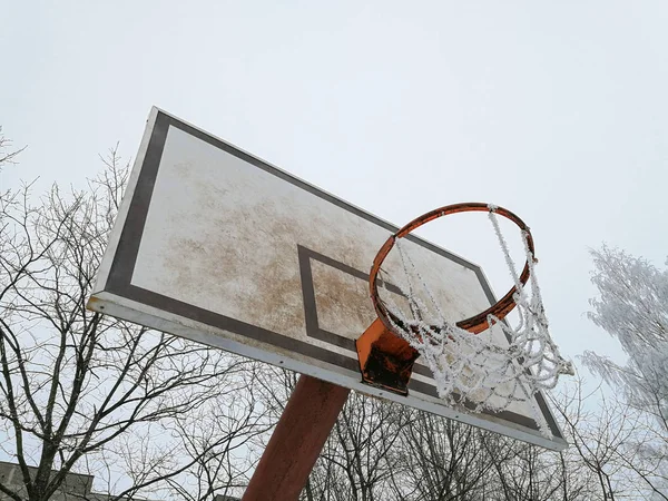 Basketball board with ice on the basketball net. Concept of abandoned places