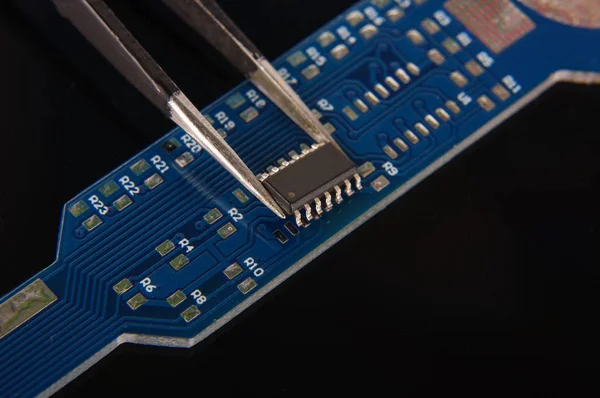 Small electronics integrated circuit IC on empty printed circuit board ready for hand assembly