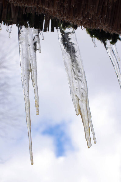 Long icicles on the roof of the house during spring time