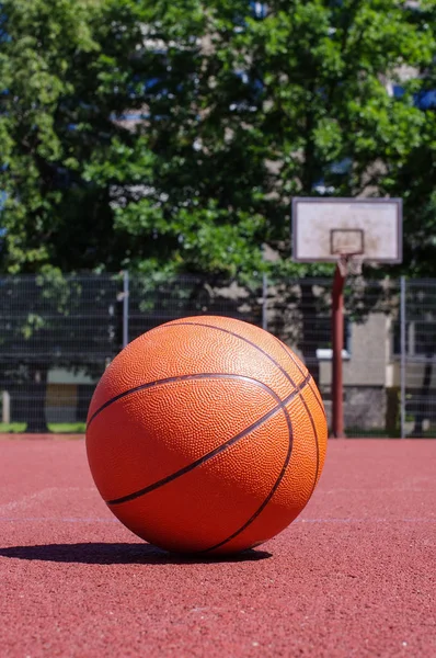 Açık havada basketbol sahası ile güneşli gün boyunca basketbol topu