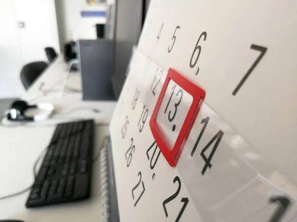 13th day marked with red marker on the office wall calendar