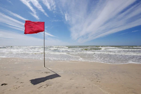 在照片中被抓获的红旗在海滩上什么意思是禁止海滩洗澡 — 图库照片
