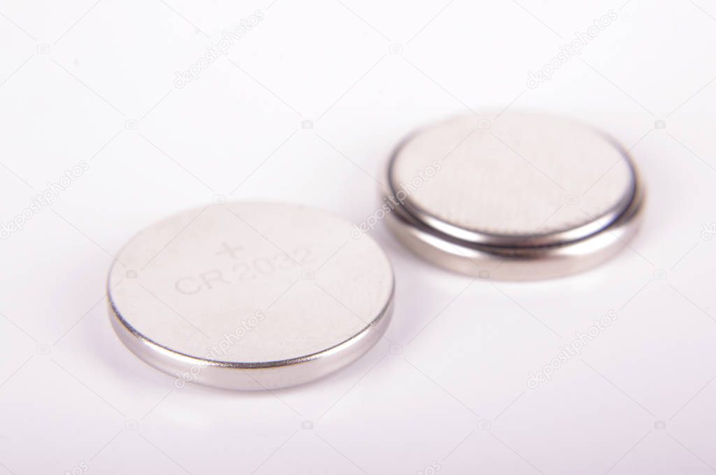 Tiny button cell CR2032 batteries both sides isolated on the white background