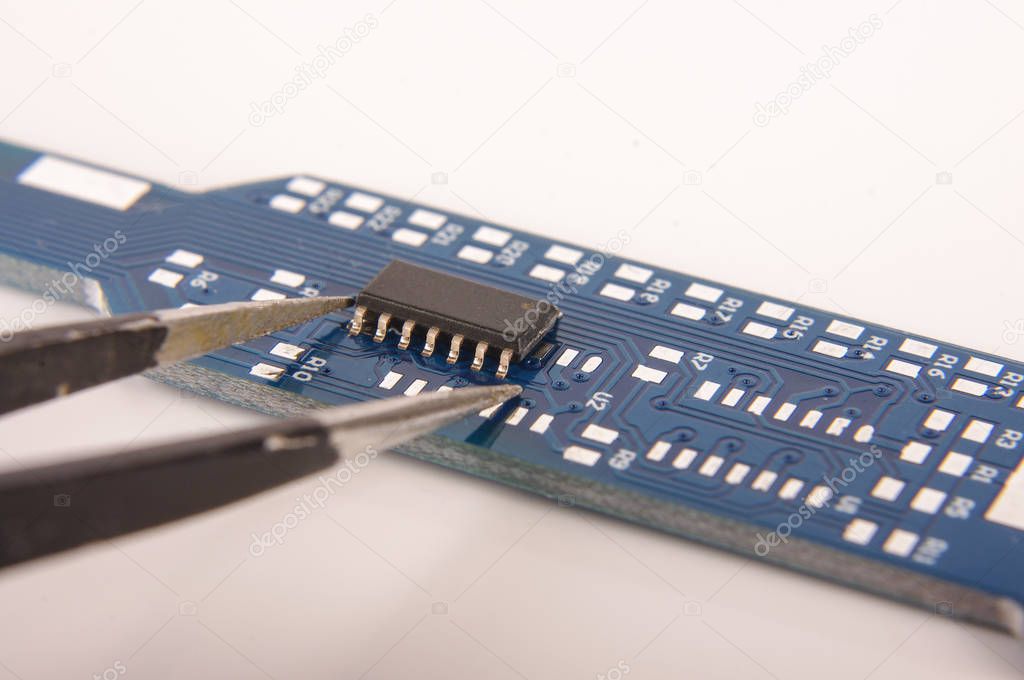 Small electronics integrated circuit IC on empty printed circuit board ready for hand assembly