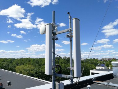 GSM (Global System for Mobile communication) baz istasyonu ve telekomünikasyon için mavi bulutlu gökyüzünün önündeki tekrarlayıcı kule