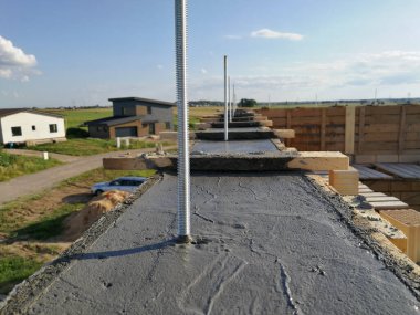 Islak betona yerleştirilmiş metal vidalar, tek bir evin çatısını onarmak için.