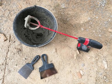 İnşaat sahasında inşaat yapıştırıcılarını karıştıran matkap yapıştırıcısı.