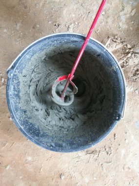 İnşaat sahasında inşaat yapıştırıcılarını karıştıran matkap yapıştırıcısı.