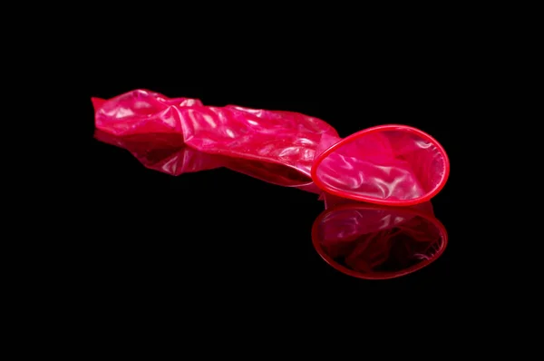 Used Pink Condom Close Sex Isolated Black Reflective Background — Stock Photo, Image