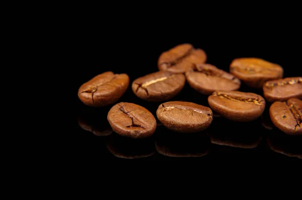 咖啡豆宏观紧密地隔离在黑色的反光背景上 — 图库照片