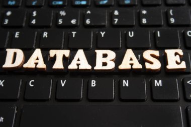 Kelime 'database' ahşap harflerin yaptı. laptop klavye arka plan üzerinde ahşap yazıt