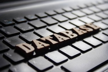 Kelime 'database' ahşap harflerin yaptı. laptop klavye arka plan üzerinde ahşap yazıt