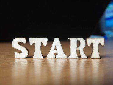 Kelime 'Başlat' ahşap harflerin yapılmış. ahşap yazıt