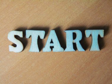 Kelime 'Başlat' ahşap harflerin yapılmış. ahşap yazıt