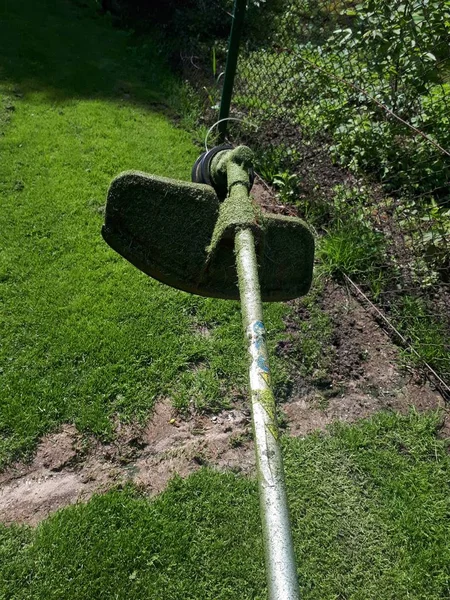 Head part of an old grass cutter machine on the grass background