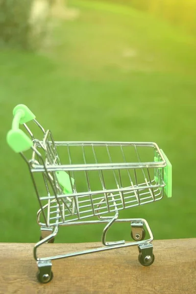 A mini shopping trolley on a table that shines on the sun symbolizing marketing and shopping as a concept of business.