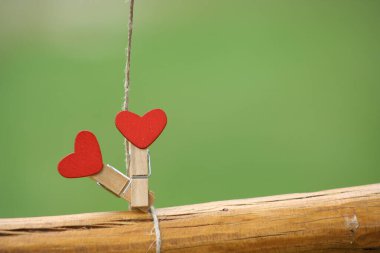 Two heart with clothespin on green background for Valendine Day card.