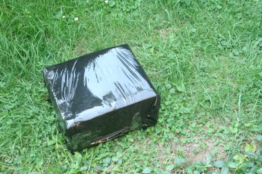 Çimlerin üzerinde duran kara kutuda bir paket. Daha ilginç mesajlar. Paketler alınıyor.