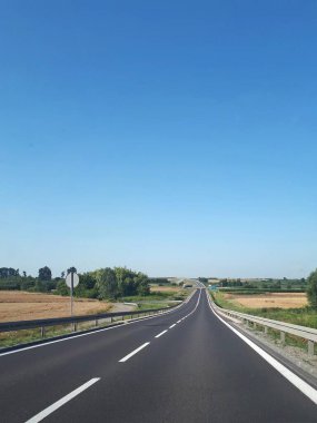 Asfalt yol yeşil tarladan geçiyor yaz günü mavi gökyüzünde 