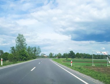 Mavi gökyüzü ve beyaz bulutlarla dolu güzel bir köy yolu.