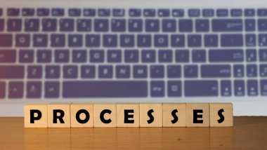 ProCESS mesaj sözcüğü tahta bir masada, küp bloklarda dizüstü bilgisayarın klavye arka planında.