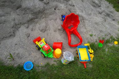 Kumsalda kum oyuncağı. Çocuk için yakın plan pastik renkli bir oyuncak. Kumun üzerindeki küçük nesneler. çocukluk kavramı.