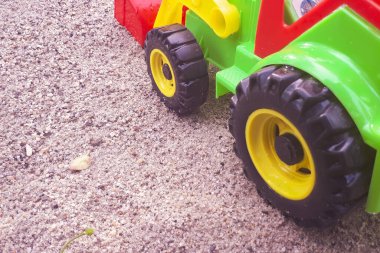 Kumsalda kum oyuncağı. Çocuk için yakın plan pastik renkli bir oyuncak. Kumun üzerindeki küçük nesneler. çocukluk kavramı.