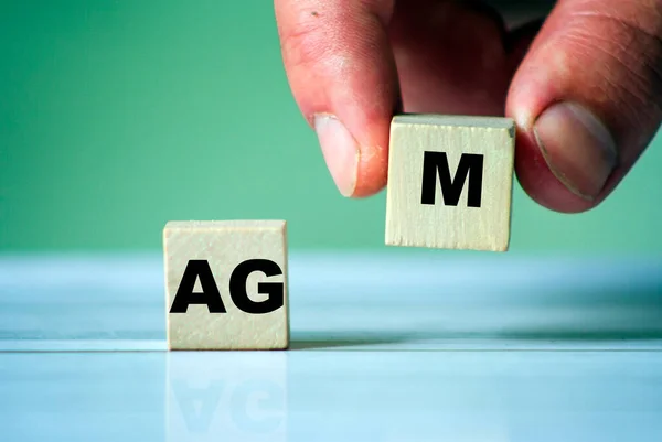 Agm符号 关于木制立方体的字Agm 手拿着一个立方体 — 图库照片