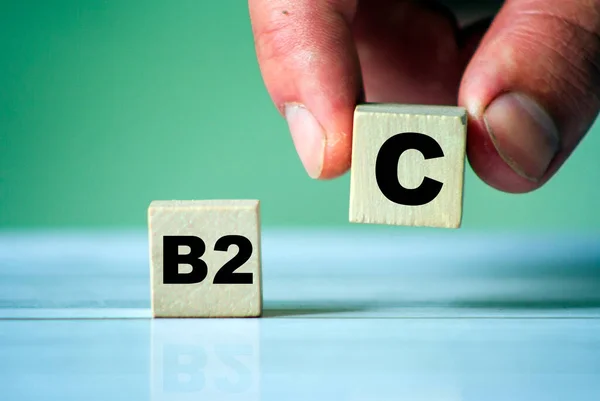 B2C 木制立方体块上有字的符号 手拿着一个立方体 企业对消费者的议题 — 图库照片
