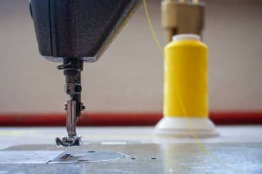 Dikiş makinesi ayak ve iğne. Yaklaş, makro. Metin için boş alan. Kumaş endüstriyel