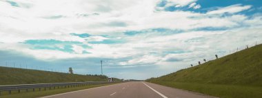 Güneşli bir günde gökyüzü bulutlu asfalt yol manzarası.