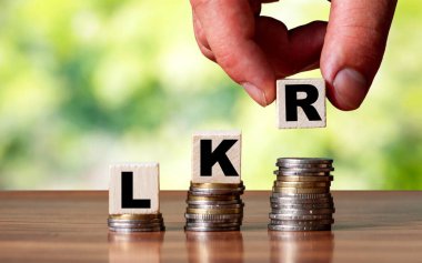 LKR sri lanka rupee kelime sembolü - iş konsepti. Eller, artan bozuk paraya tahta blok koydu..