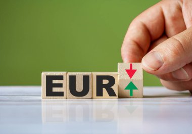 EUR konsepti olarak el, kırmızı ve yeşil oklu ahşap bloğu değiştiriyor. Sözcük EUR kavramsal sembol.