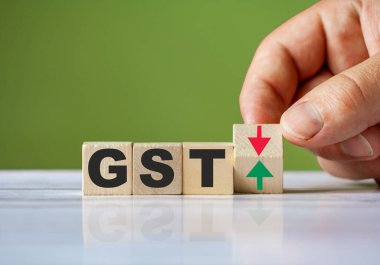 El, GST kavramını değiştirmek için kırmızı ve yeşil oklu tahta bloğu döndürür. Sözcük GST kavramsal sembolü.