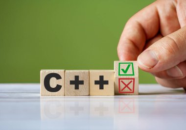 Kırmızıyla ahşap bloğu çeviren X ve yeşil kene C + + konseptini onaylıyor. Kelime C + + kavramsal sembol.