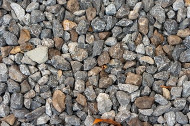 Küçük yol taşı arka planı, koyu çakıl taşı taş dokusu. Çakıl taşlarına yakın çekim. Bahçedeki çakıllar. Desen.