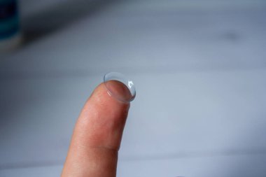 Kontak lensler makroyu kapat. Parmağında lens tutan adam..