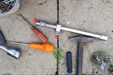 Gri beton arka planda eski çalışma aracı. Garajın beton zemininde eski anahtarlar..