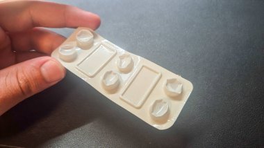 Bir insan içinde birden fazla kompartıman bulunan boş bir ilaç paketi bulundurur. Paket, ilaç paketlemesinin kolaylık ve kullanıcı dostu tasarımını gösteren haplara kolay erişim için tasarlandı..