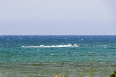 Güneşli bir günde okyanusta jet ski süren iki kişi berrak mavi sular ve canlandırıcı bir deniz macerası sergiliyorlar..