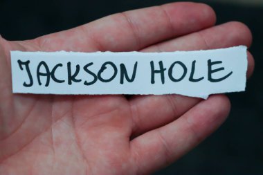 Jackson Hole 'un bir insanın elinde olduğunu söyleyen el yazısıyla yazılmış bir not. Bu görüntü, Wyoming 'deki seyahat macerasının ve keşiflerin özünü yakalar..
