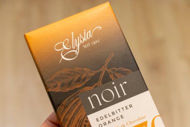 Varşova Polonya - 4 Ağustos 2025: Elysia koyu çikolatasının portakal aromalı zarif ambalaj ve logo tasarımlı yakın çekimi. Gıda pazarlaması için ideal..