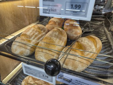 Lahde Almanya - 15 Nisan 2025: Fırında taze ekmek ruloları sergileniyor. Kabuklu somunlar altın kahverengi renkler ve kırsal bir his ile çekicidir..