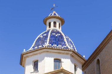 Altea Spain - 17 Temmuz 2025: Mimari güzellik ve kültür mirasını vurgulayan açık mavi gökyüzü altında geleneksel mavi fayansların yer aldığı bir kilise kubbesinin çarpıcı manzarası.
