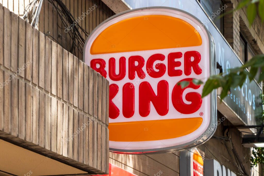 Alicante Spain - July 14 2025: A vibrant Burger King sign prominently displayed on a city street showcasing fast food culture in an urban setting.